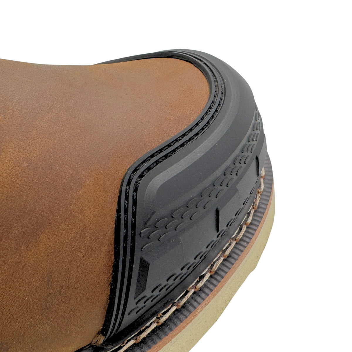 Close-up detail of work boot toe cap showing rubber guard and textured sole construction
