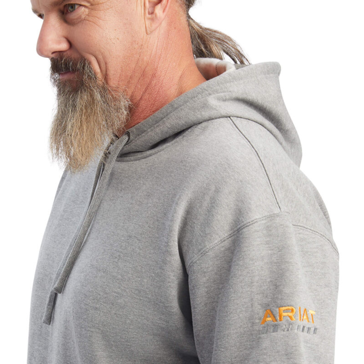 Man wearing grey Ariat hoodie, close-up side view showing sleeve logo detail