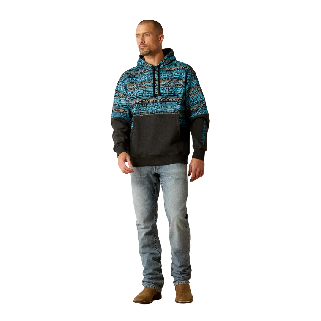 Man wearing a color block hoodie with turquoise Aztec print upper and dark lower half