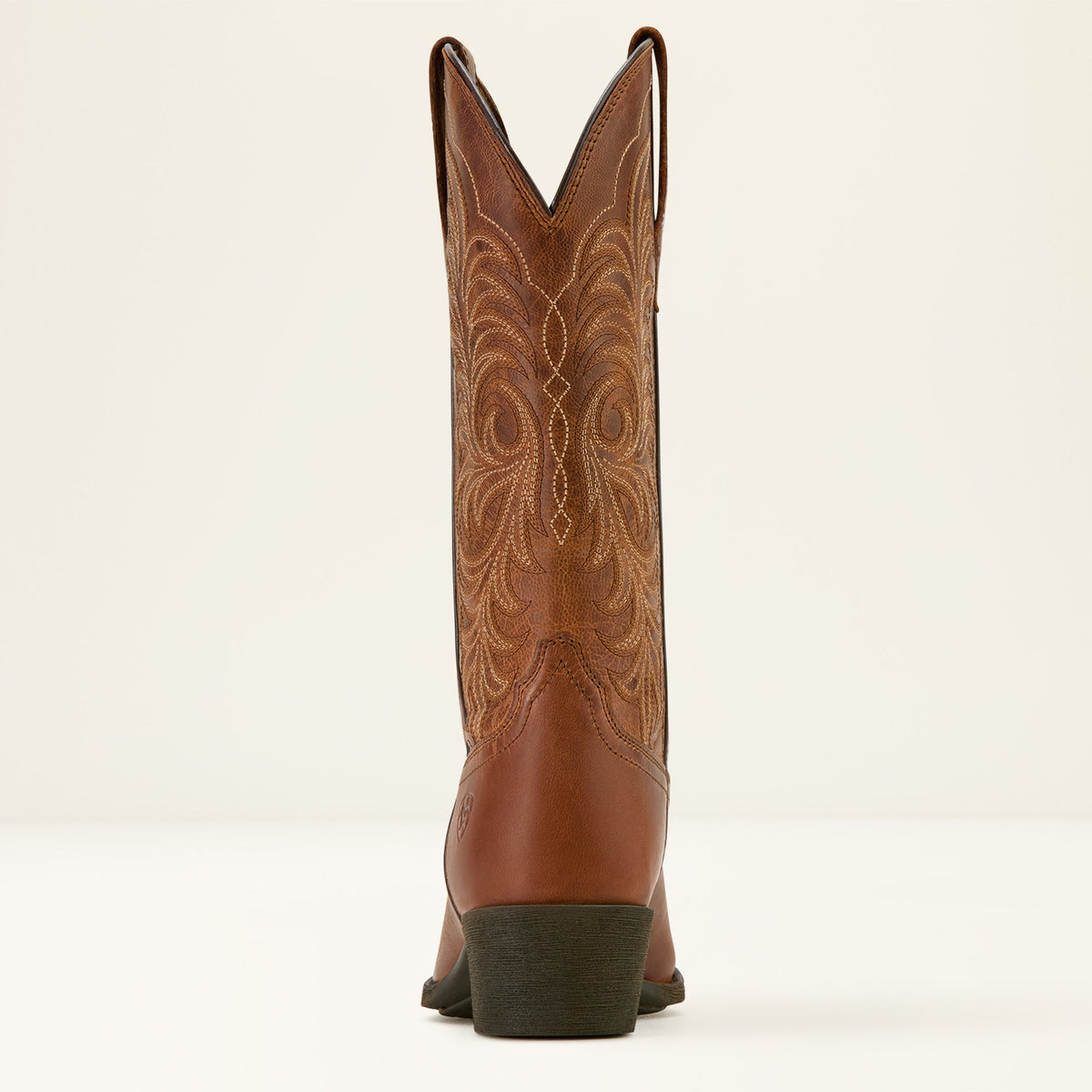Rear view of a tall western cowboy boot with intricate scroll embroidery on shaft