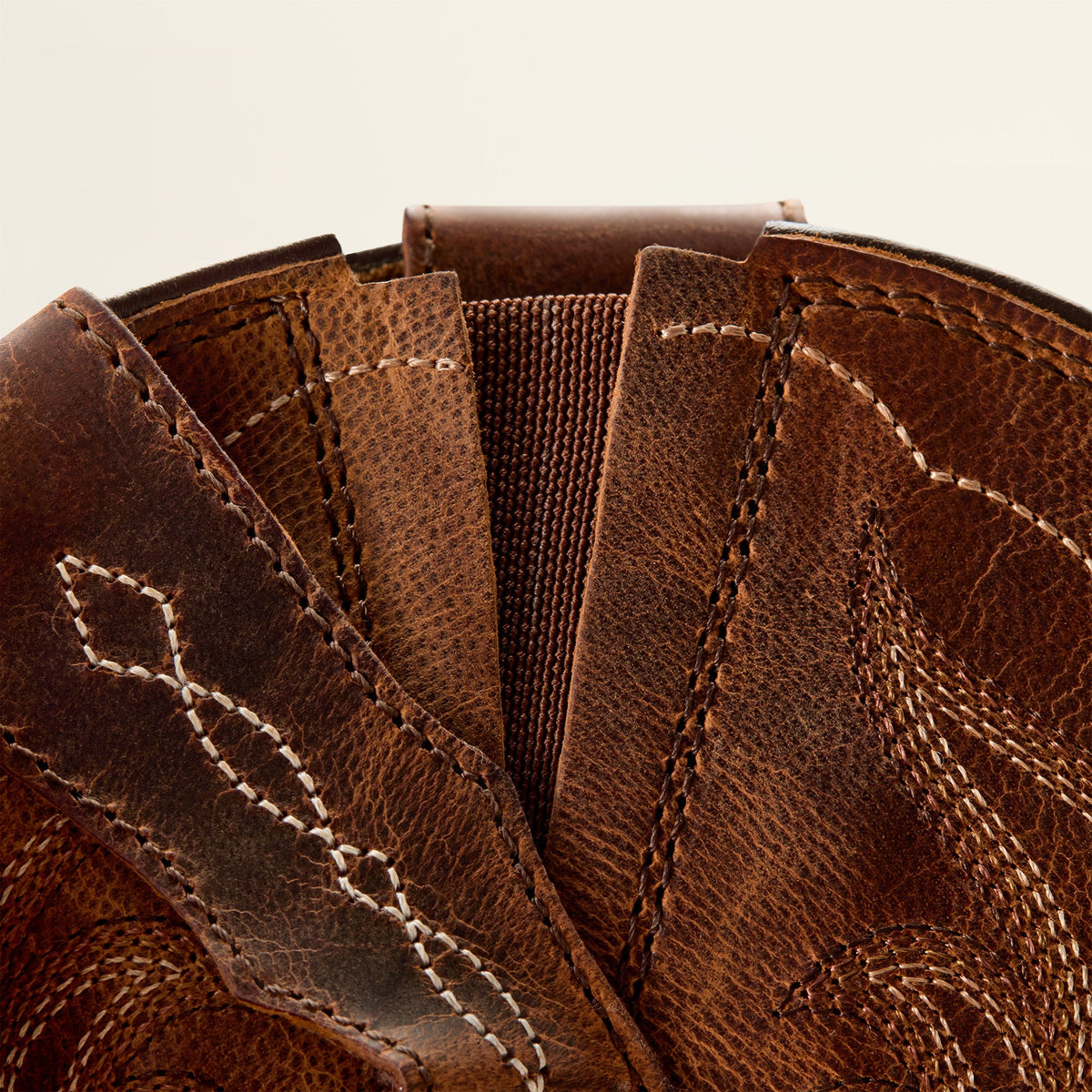 Close-up detail of brown leather boot shaft showing stitching and elastic gore panel