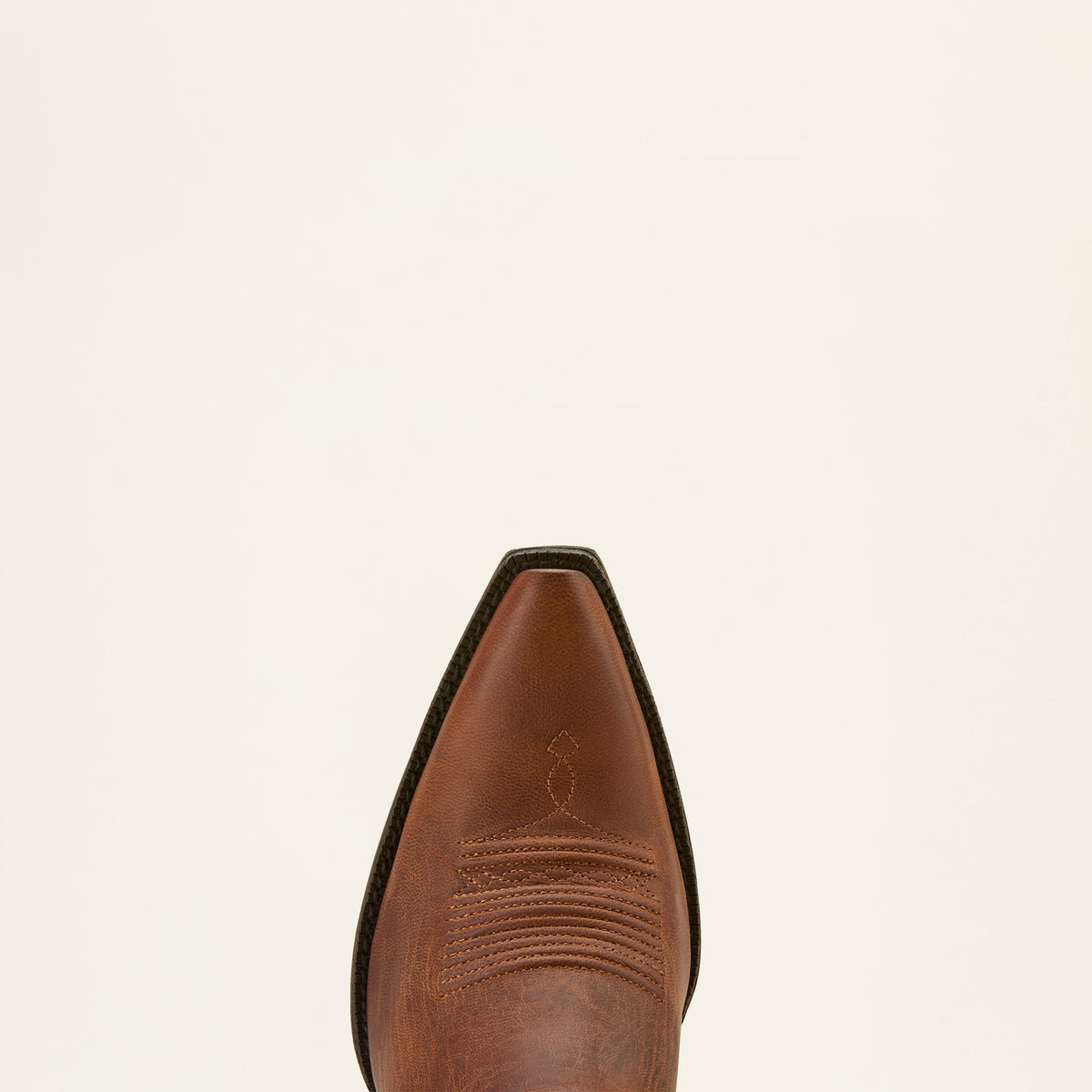 Close-up top view of a pointed-toe brown leather western cowboy boot with stitching detail