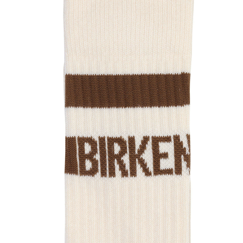 Close-up detail of a cream ribbed sock featuring a brown stripe and Birkenstock logo text