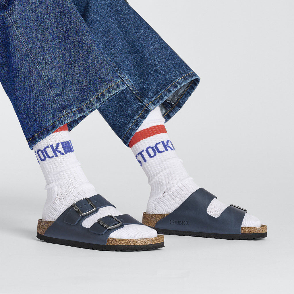 White Birkenstock cotton stripe crew socks worn with navy sandals and cropped denim jeans