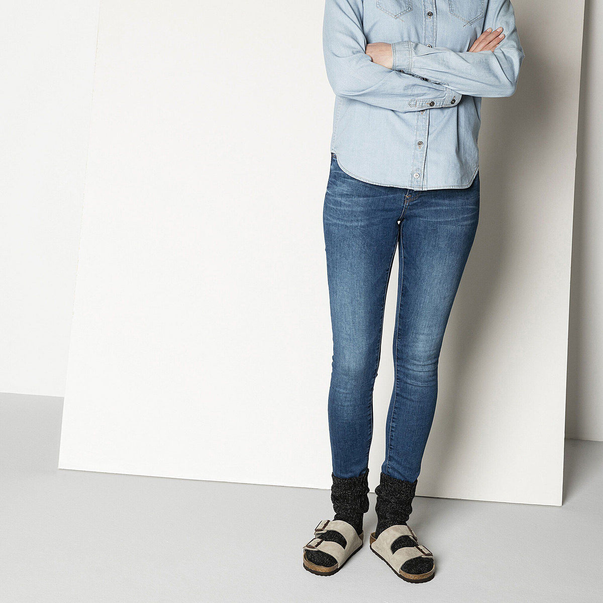 Model wearing black cotton twist socks with Birkenstock sandals and blue skinny jeans