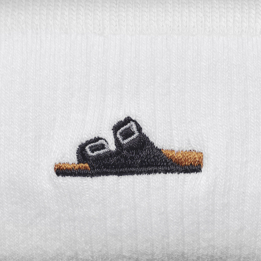 Embroidered Birkenstock sandal motif detail on white ribbed cotton fabric