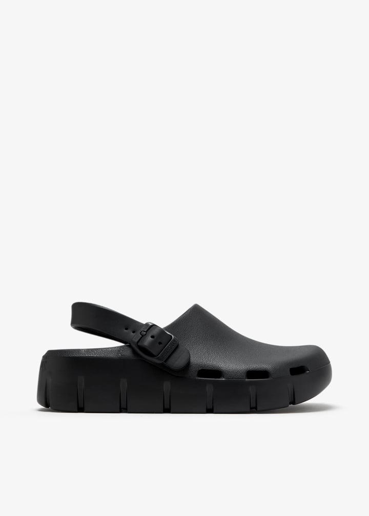Black EVA clog with buckle back strap and chunky ridged platform sole, side view