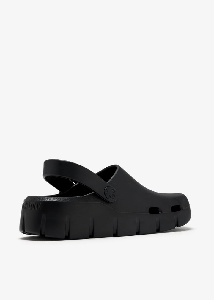 Birkenstock black EVA clog with back strap shown from rear three-quarter angle