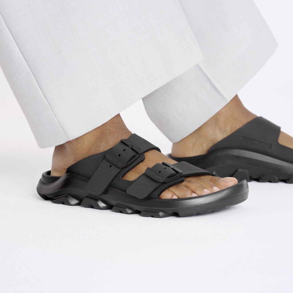 Birkenstock double-strap buckle sandals with chunky lug sole worn with wide-leg trousers
