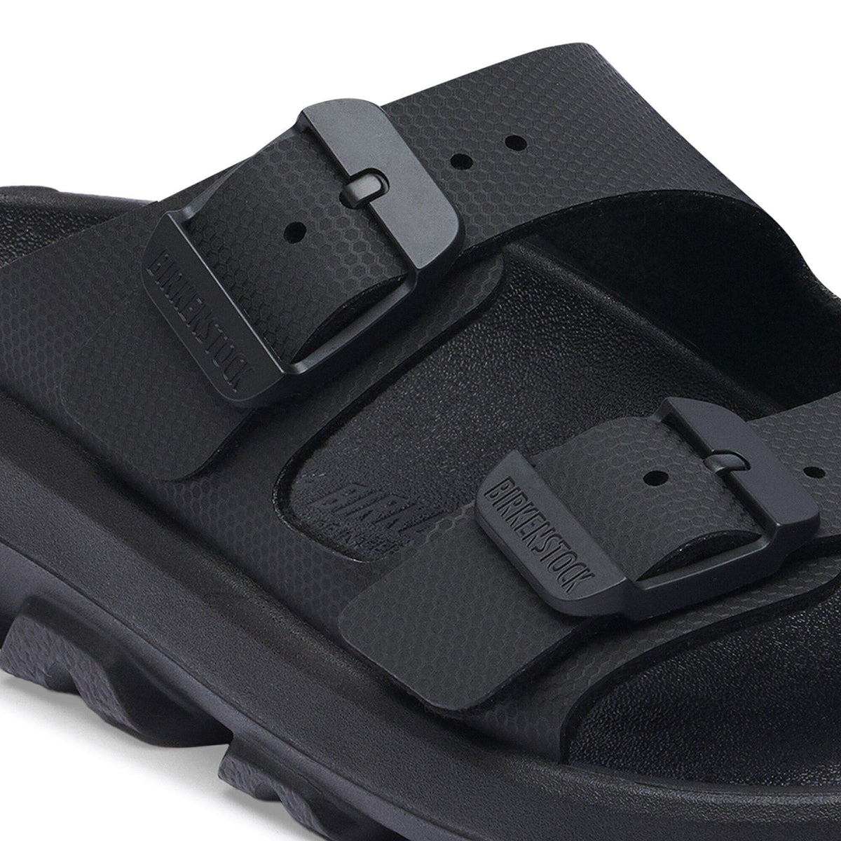 Close-up detail of Birkenstock double-buckle slide sandal showing textured straps and chunky sole