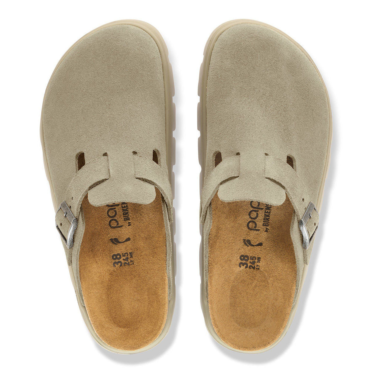 Top-down view of a pair of taupe suede closed-toe clogs with buckle strap detail