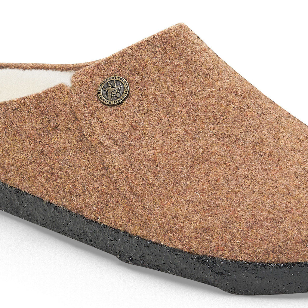 Close-up detail of a felted wool clog slipper with shearling lining and black rubber sole