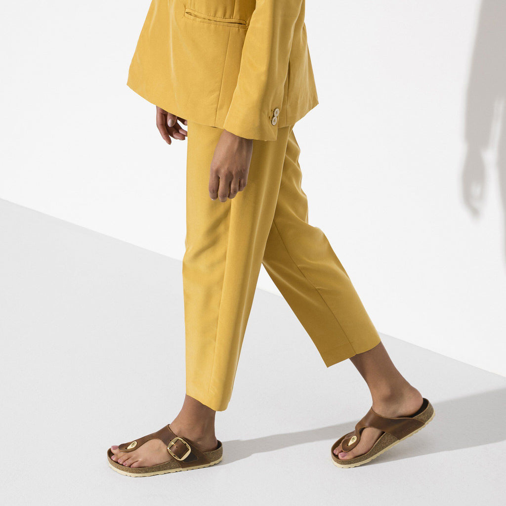 Model walking wearing Birkenstock Gizeh Big Buckle thong sandals with gold hardware