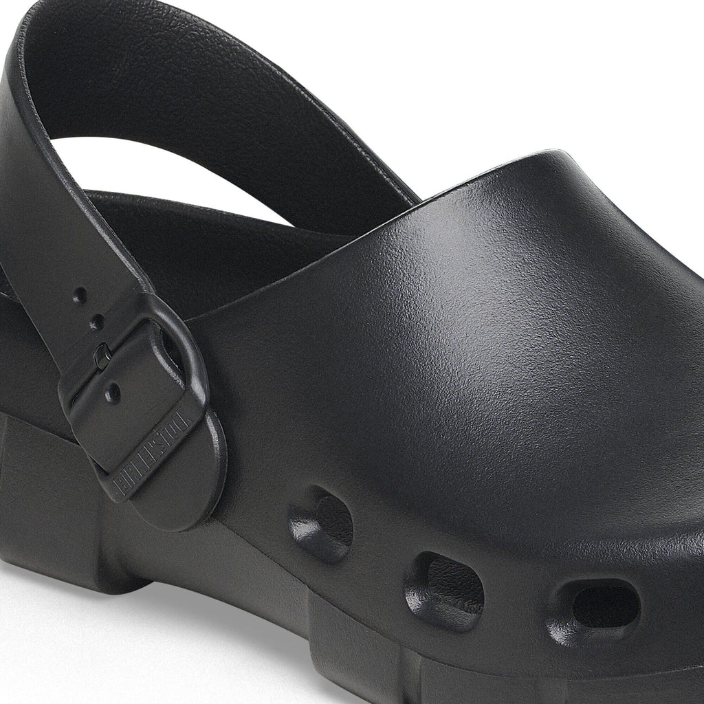 Close-up detail of a black clog sandal with ankle strap buckle and ventilation holes