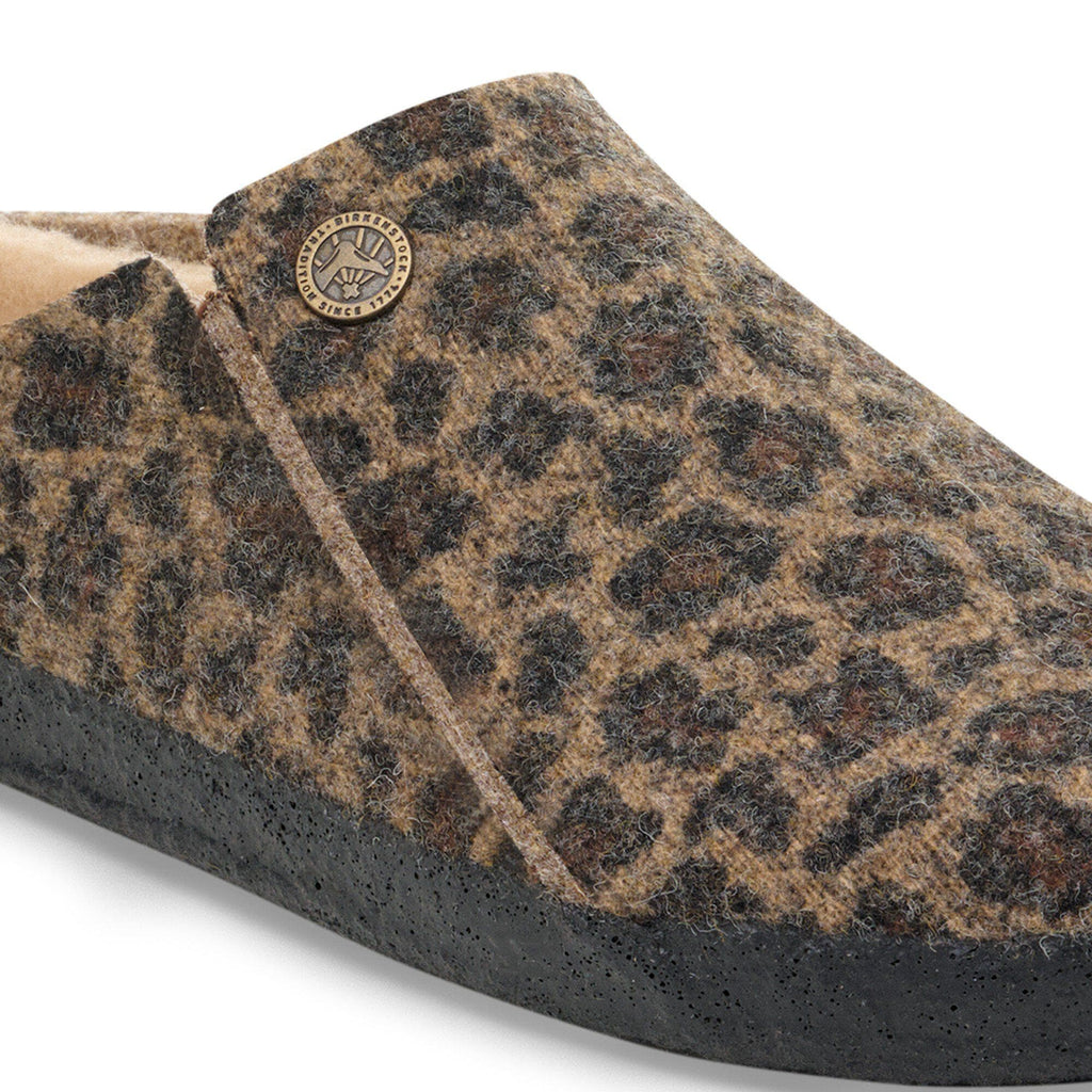 Close-up detail of Birkenstock shearling slipper in leopard-print felt with metal logo badge