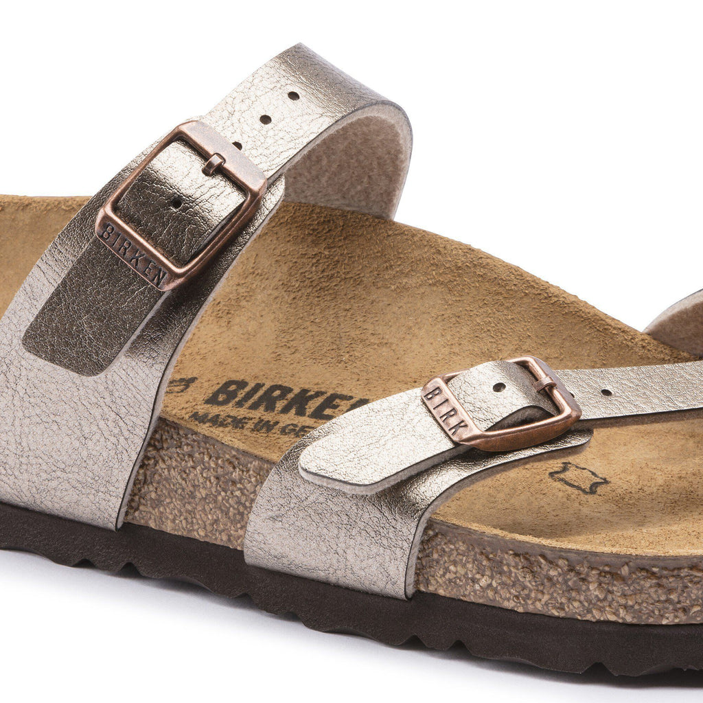 Close-up detail of Birkenstock Mayari sandal showing metallic straps with rose gold buckles and cork footbed
