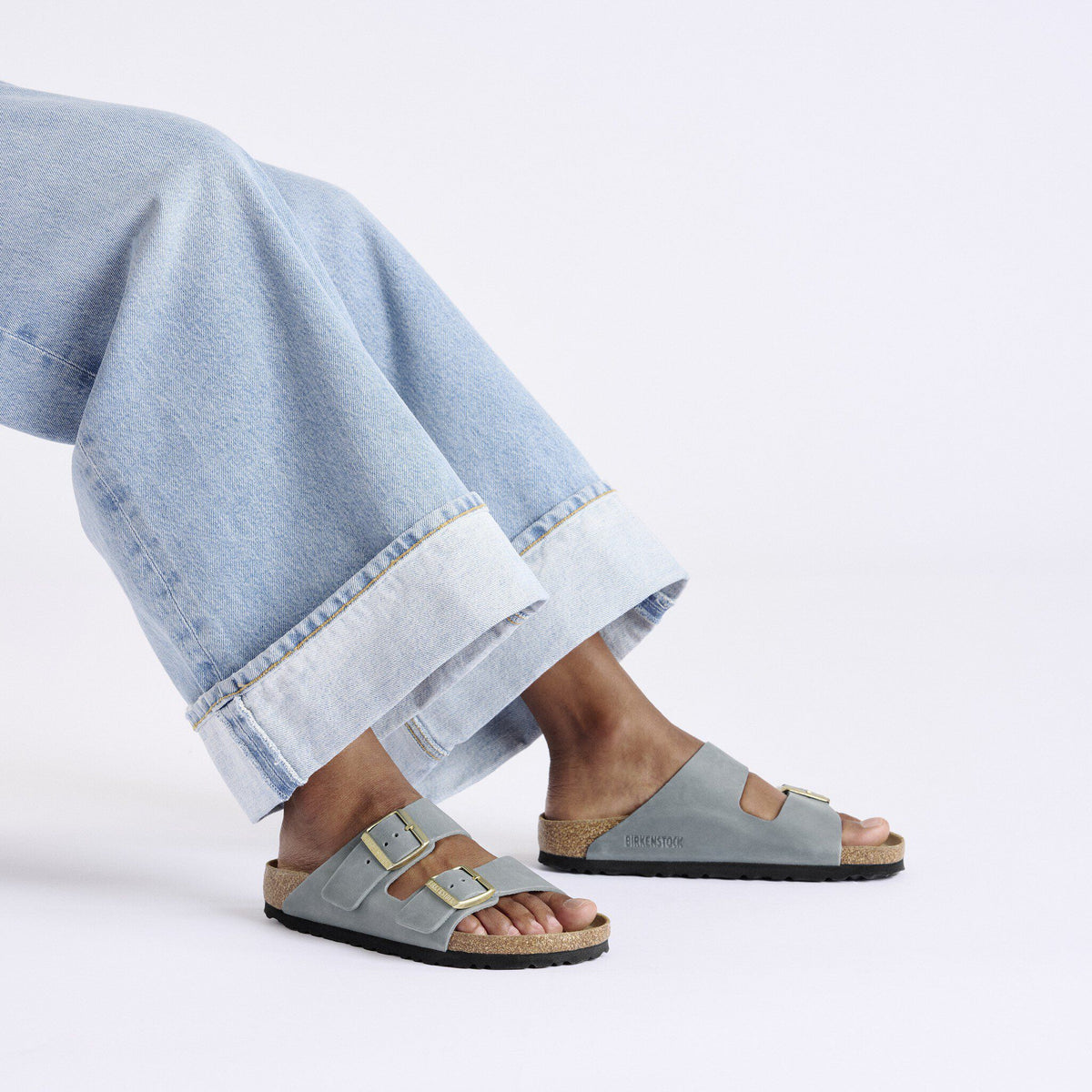 Birkenstock Arizona sandals with double buckle straps worn with wide-leg cuffed jeans