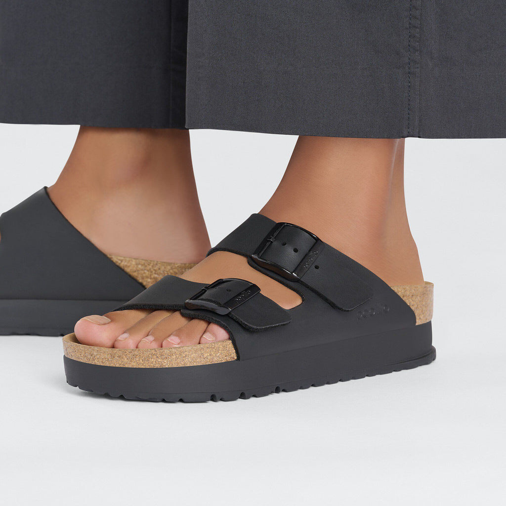 Birkenstock Arizona Platform Vegan sandals worn on feet with grey wide-leg trousers