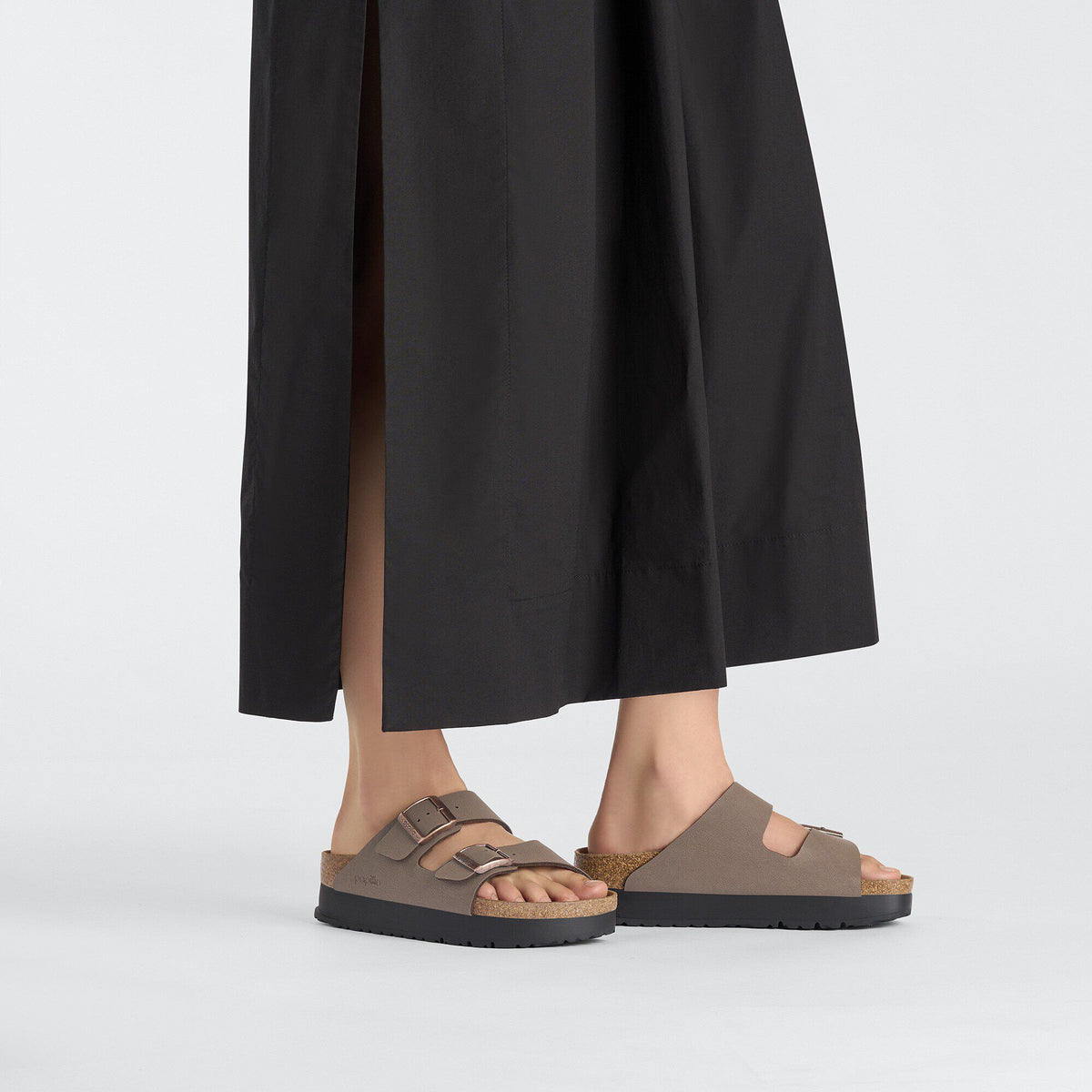 Model wearing Birkenstock Arizona Platform sandals with double buckle straps and cork footbed