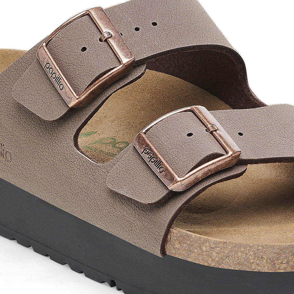 Close-up detail of two adjustable buckle straps on a platform sandal with cork footbed