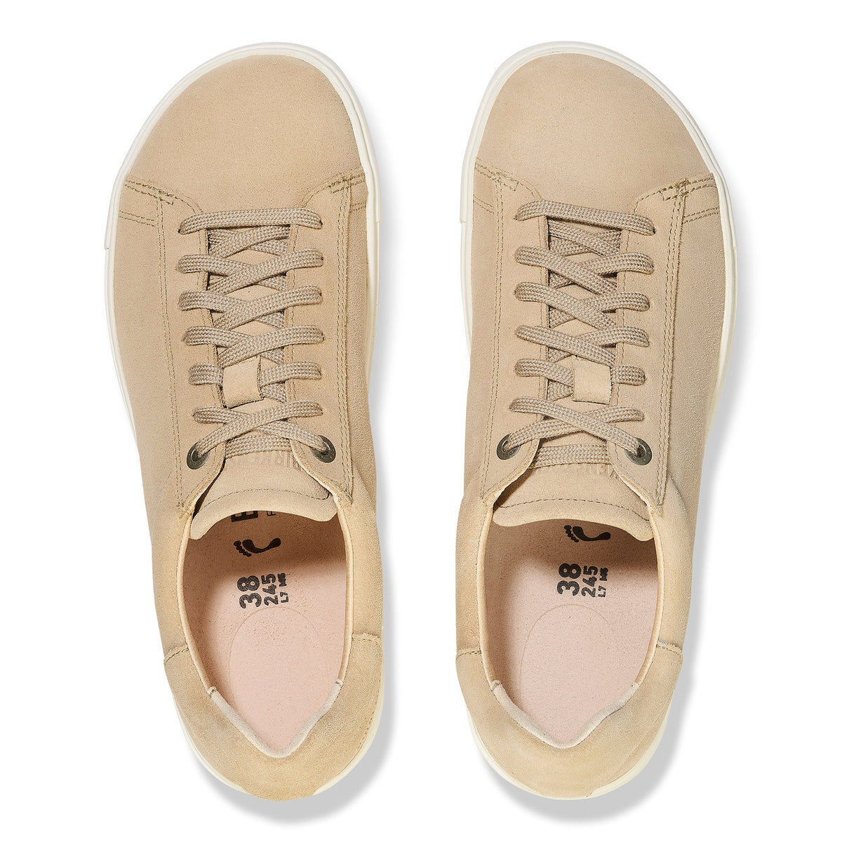 Top-down view of a pair of beige suede lace-up low-top sneakers with white soles