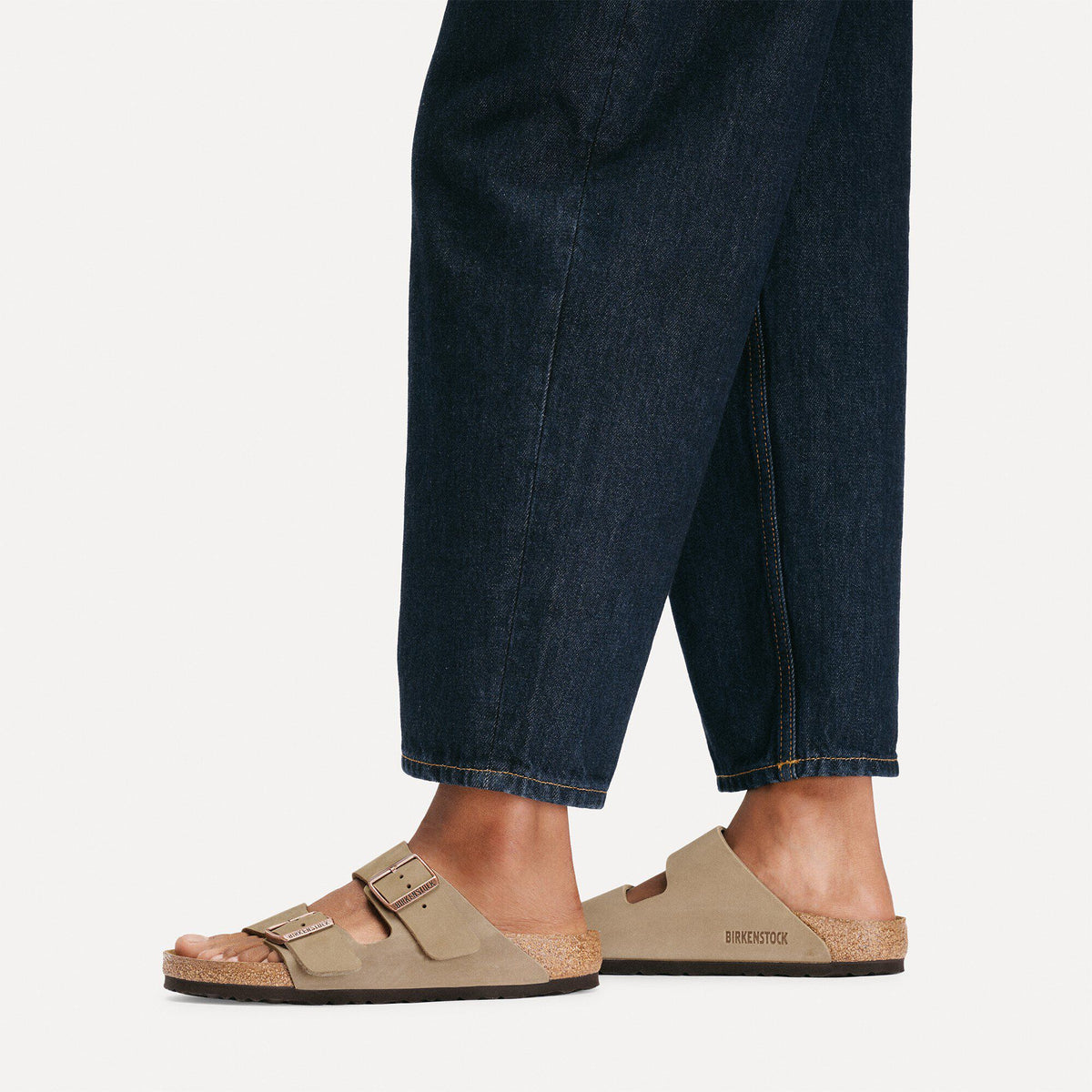 Birkenstock Arizona two-strap sandals worn with dark cropped denim jeans on model