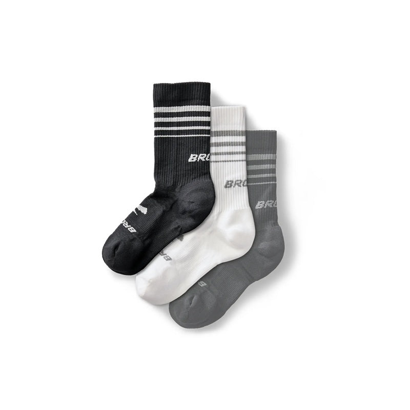 Three crew socks in black, white, and gray with stripe detail and Brooks branding