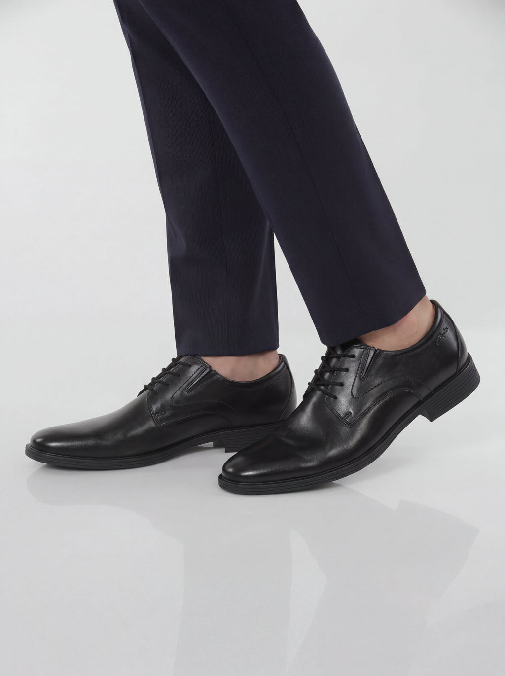 Men wearing black leather lace-up Derby dress shoes with navy suit trousers