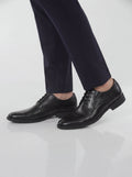 Men wearing black leather lace-up Derby dress shoes with navy suit trousers