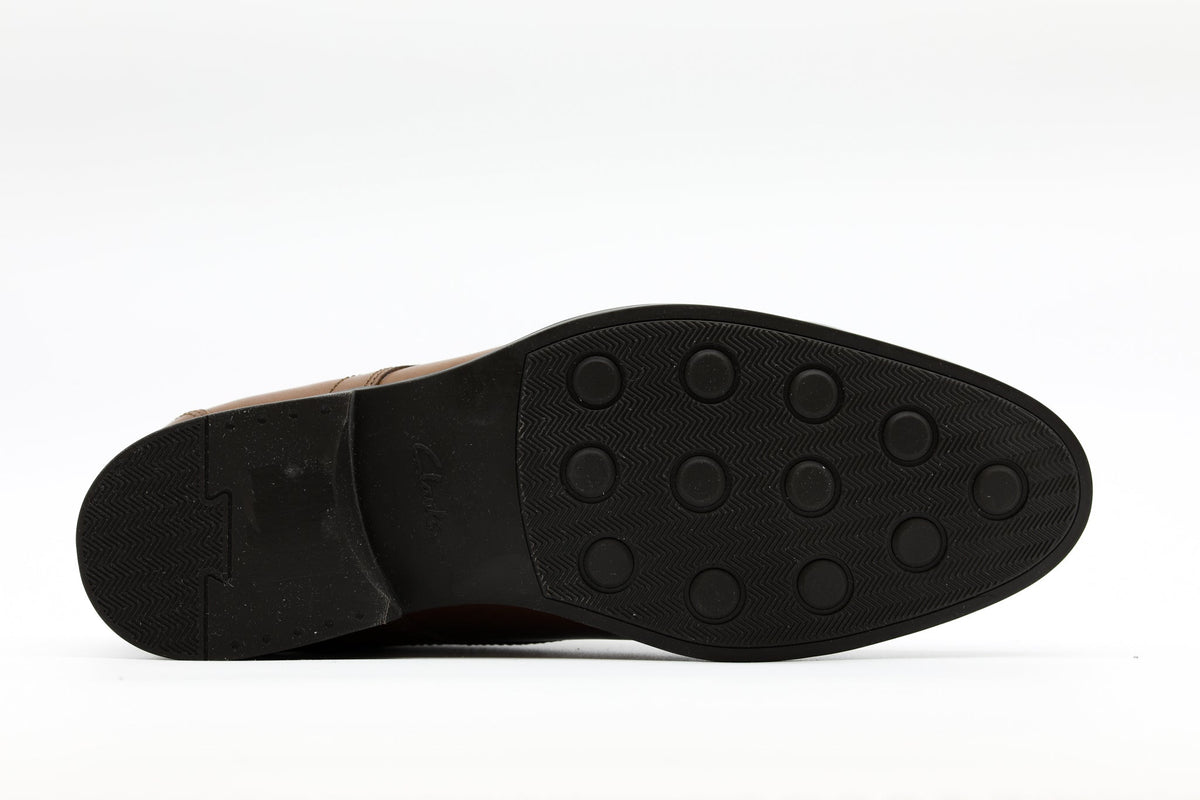 Bottom sole view of a Clarks men's leather dress shoe showing rubber tread pattern