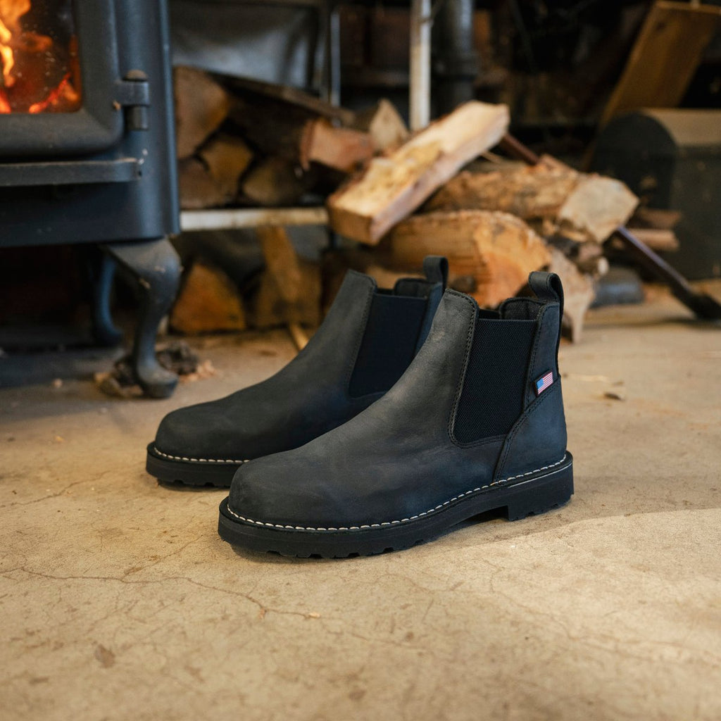 Danner Bull Run Chelsea 6-inch soft toe boots displayed near a wood-burning stove