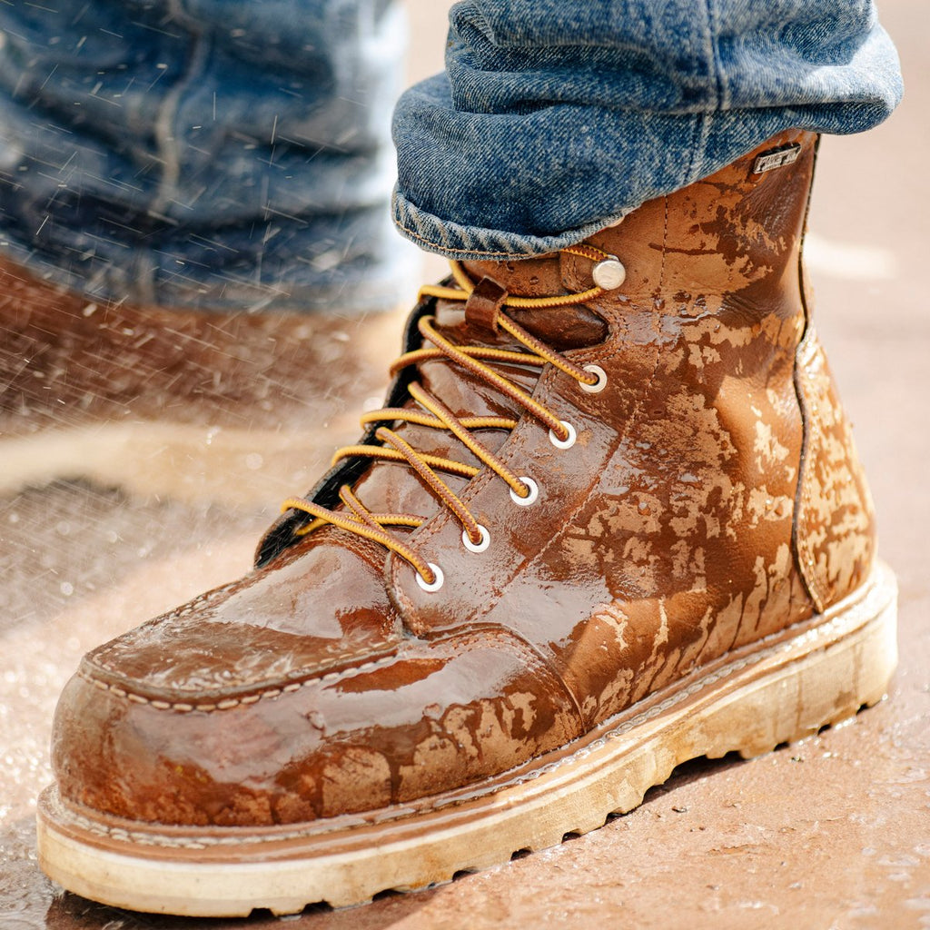 Danner men's lace-up leather work boot with moc toe worn in wet rainy conditions