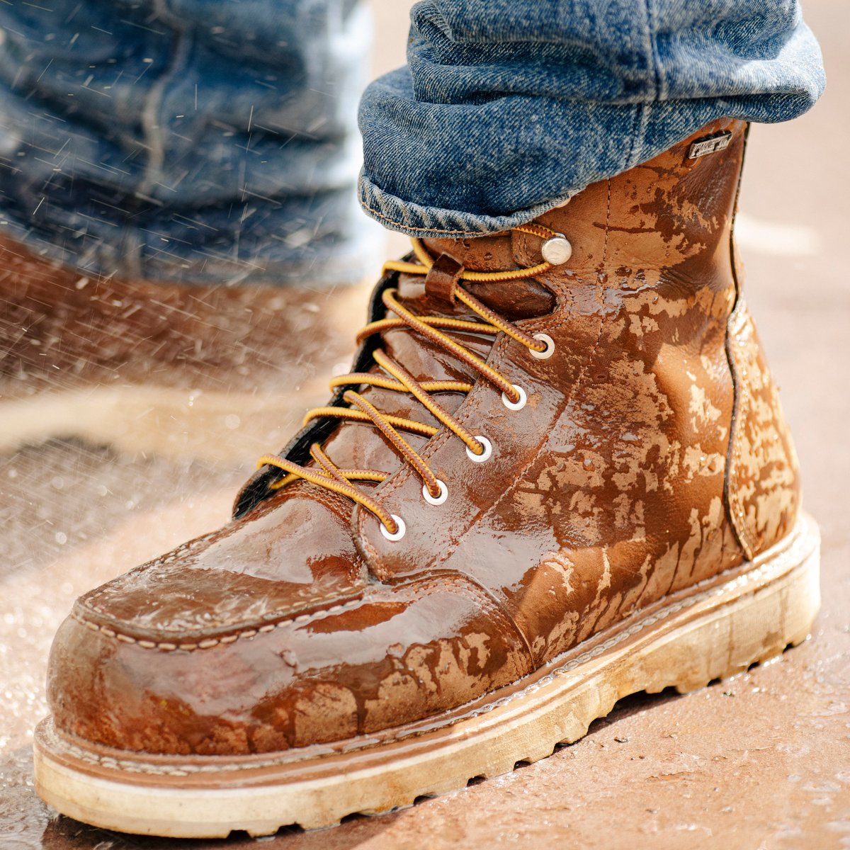 Danner men's lace-up leather work boot with moc toe worn in wet rainy conditions