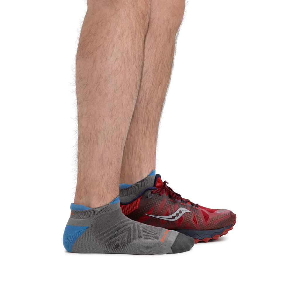 Men's gray no-show tab running sock worn with red trail running shoe, side view