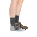 Woman wearing Darn Tough gray micro crew hiking socks with brown trail shoes, side view