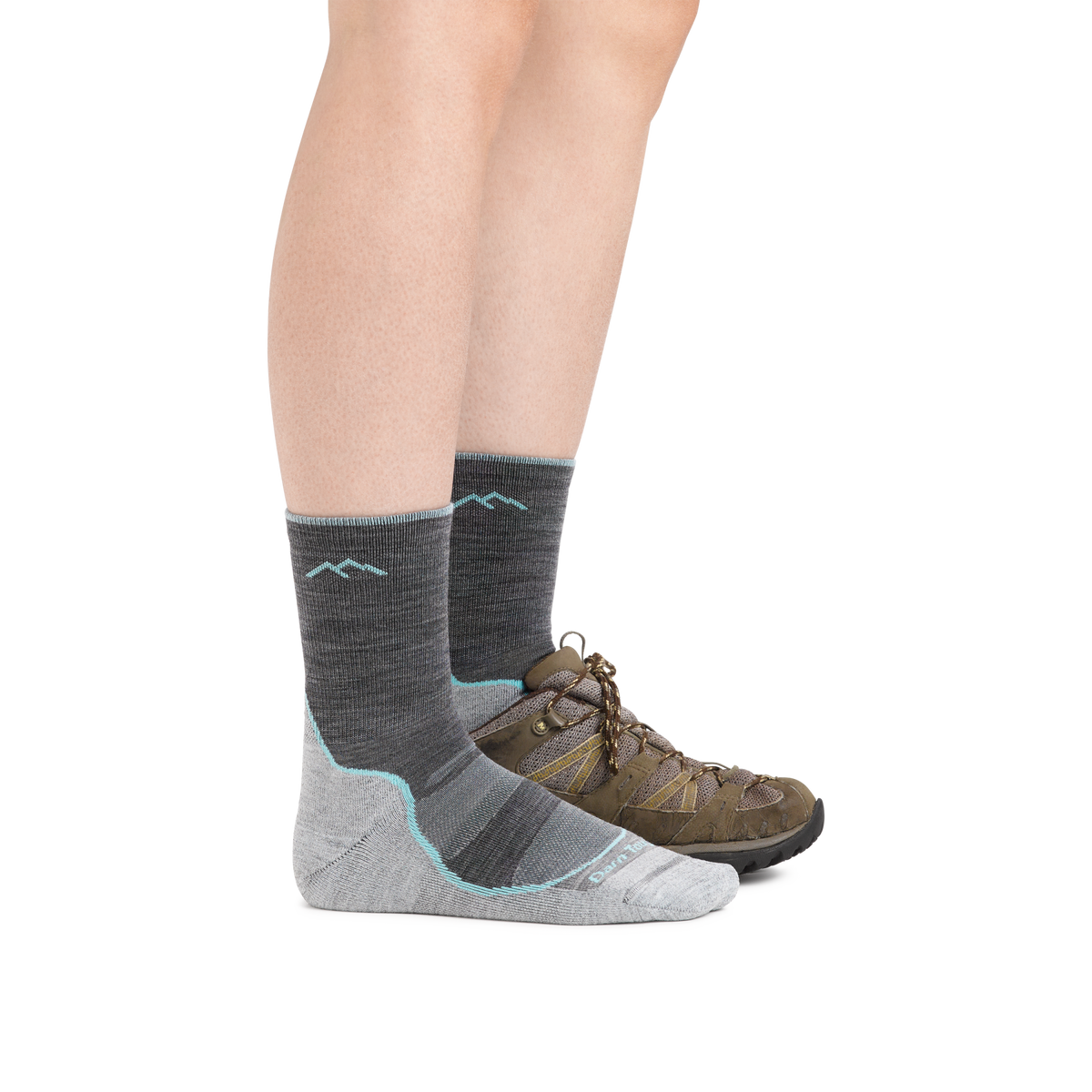 Woman wearing Darn Tough gray micro crew hiking socks with brown trail shoes, side view