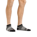 Model wearing Darn Tough no-show ankle socks with charcoal and gray striped pattern