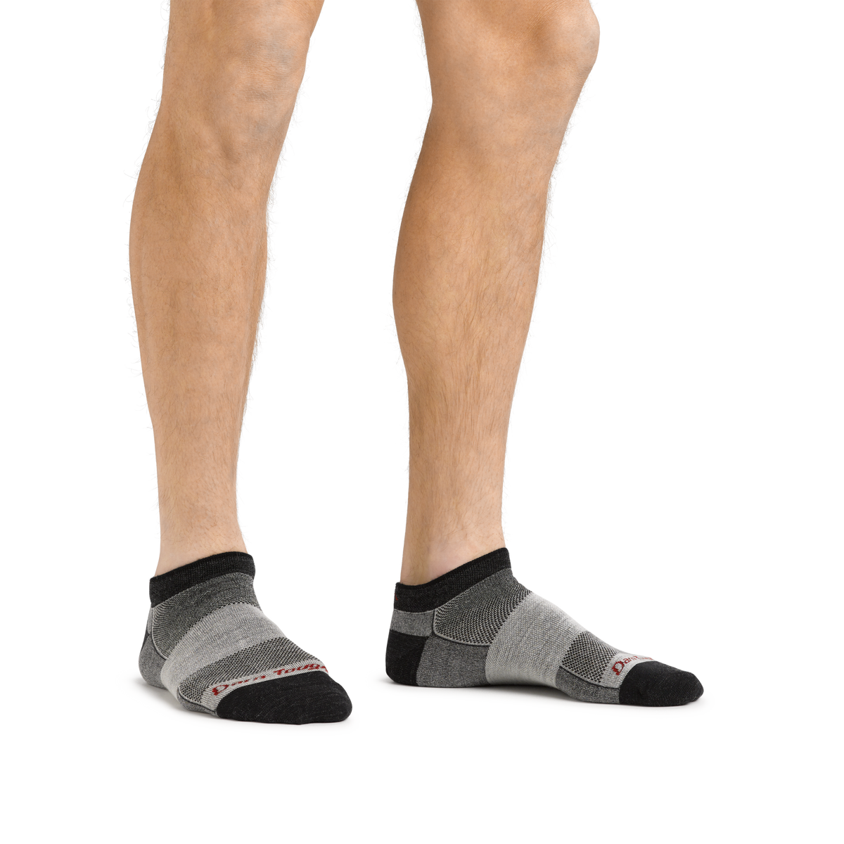 Model wearing Darn Tough no-show ankle socks with charcoal and gray striped pattern