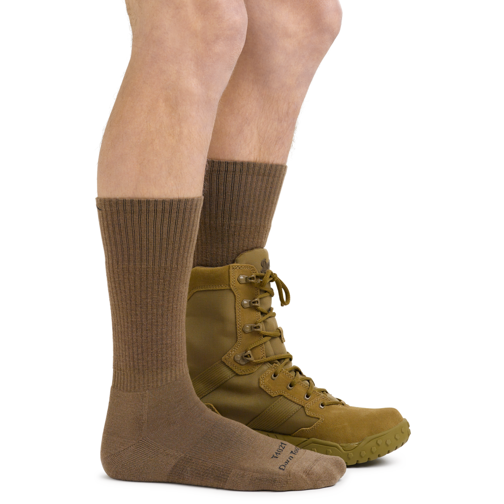 Model wearing tan Darn Tough tactical boot socks with lace-up military boots, side view