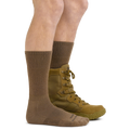 Model wearing tan Darn Tough tactical boot socks with lace-up military boots, side view