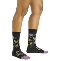 Woman wearing dark charcoal crew socks with purple floral and green leaf pattern