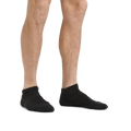 Male model wearing black no-show ankle socks displayed against white background