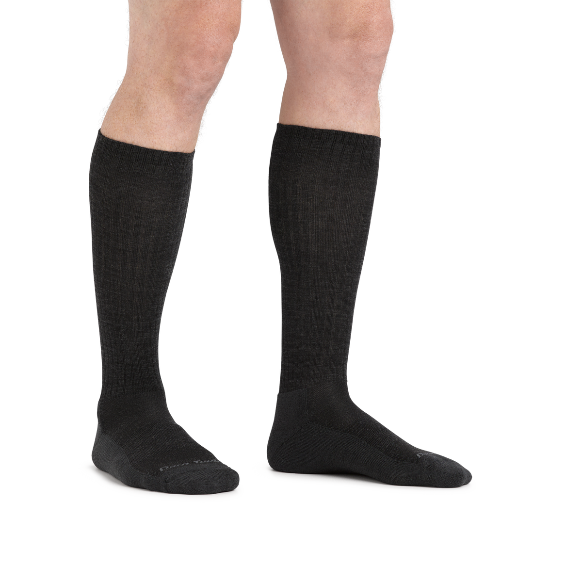 Man wearing Darn Tough mid-calf cushioned socks shown from knees down, standing pose