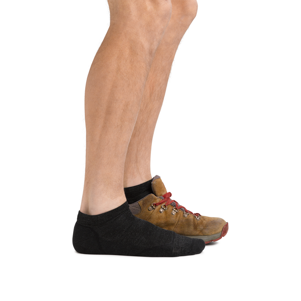 Side view of legs wearing black no-show socks paired with tan leather hiking shoes