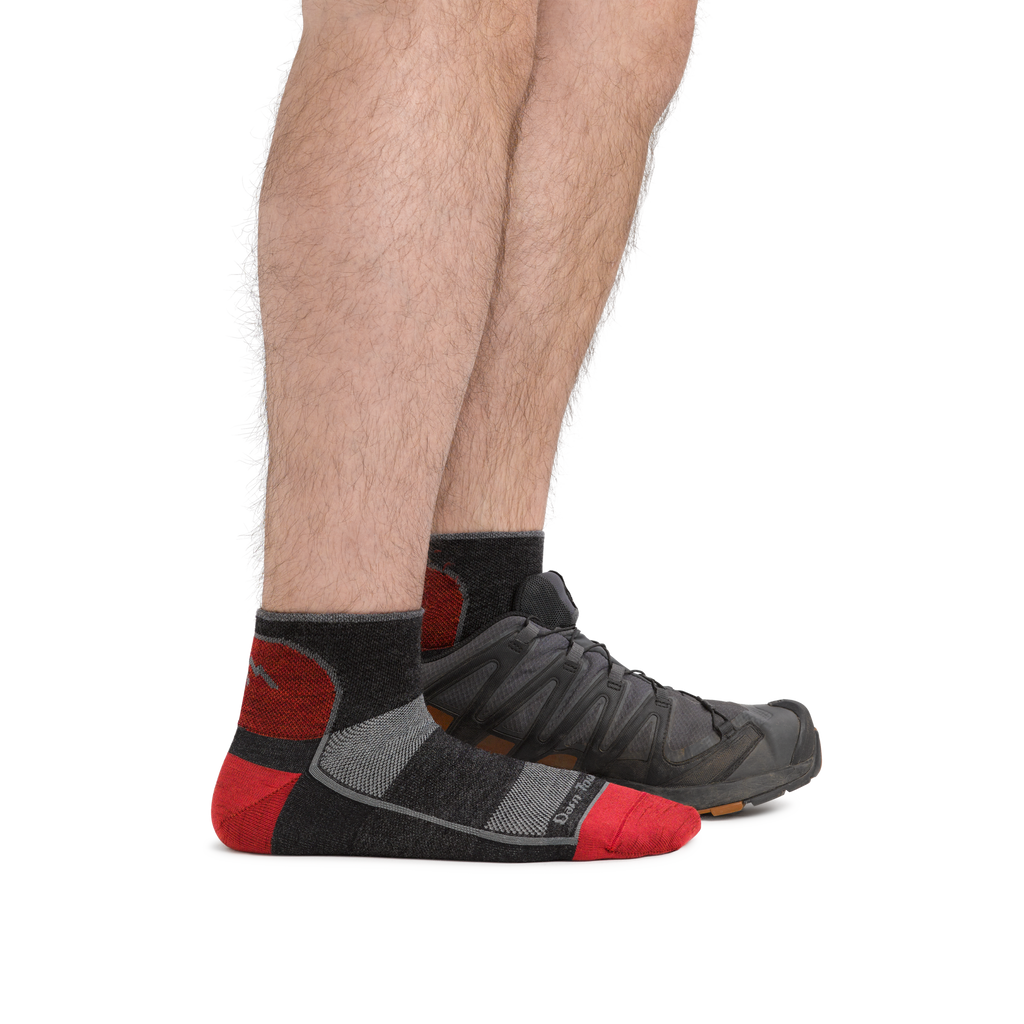Man wearing Darn Tough quarter-length cushioned running socks with trail shoes, side view
