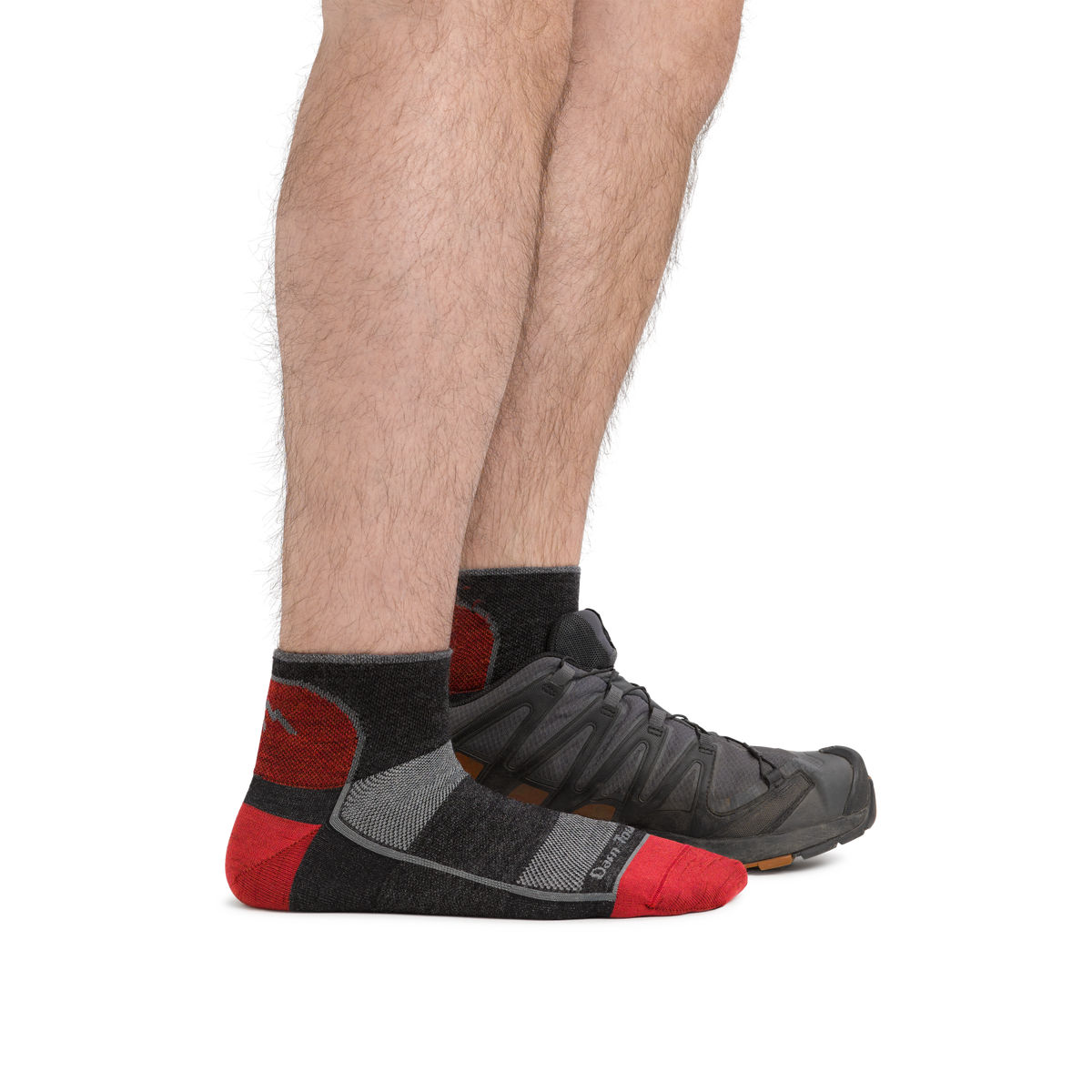 Man wearing Darn Tough quarter-length cushioned running socks with trail shoes, side view