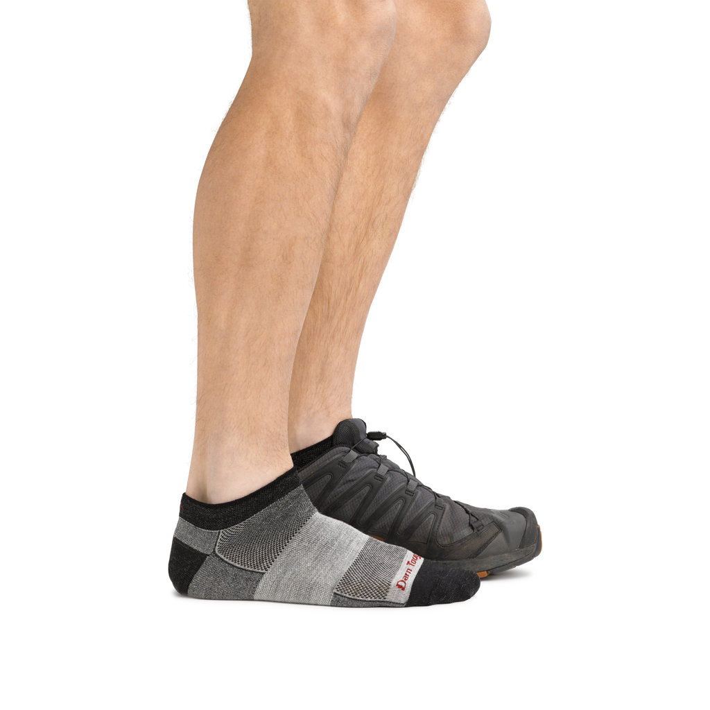 Side view of legs wearing Darn Tough no-show running socks with athletic trail shoes