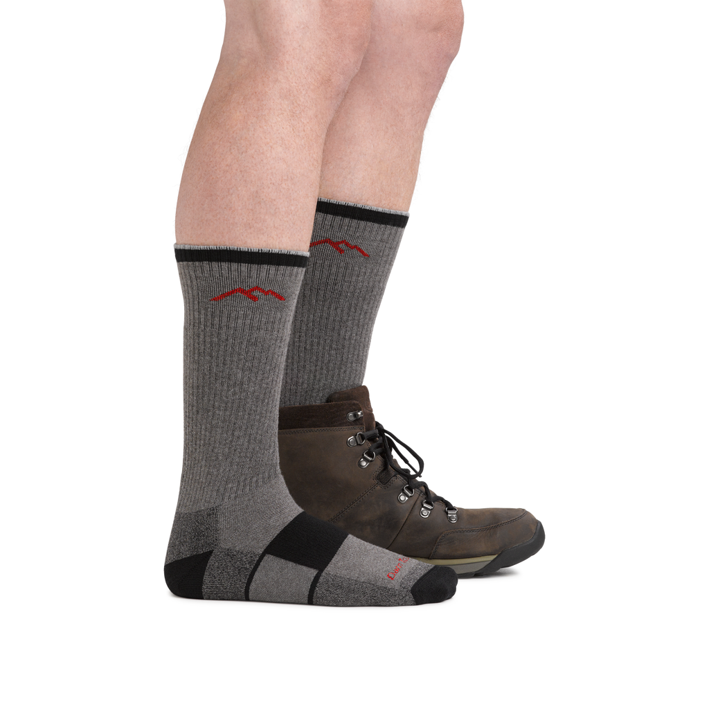 Model wearing gray and black Darn Tough hiking boot socks with brown leather hiking boots