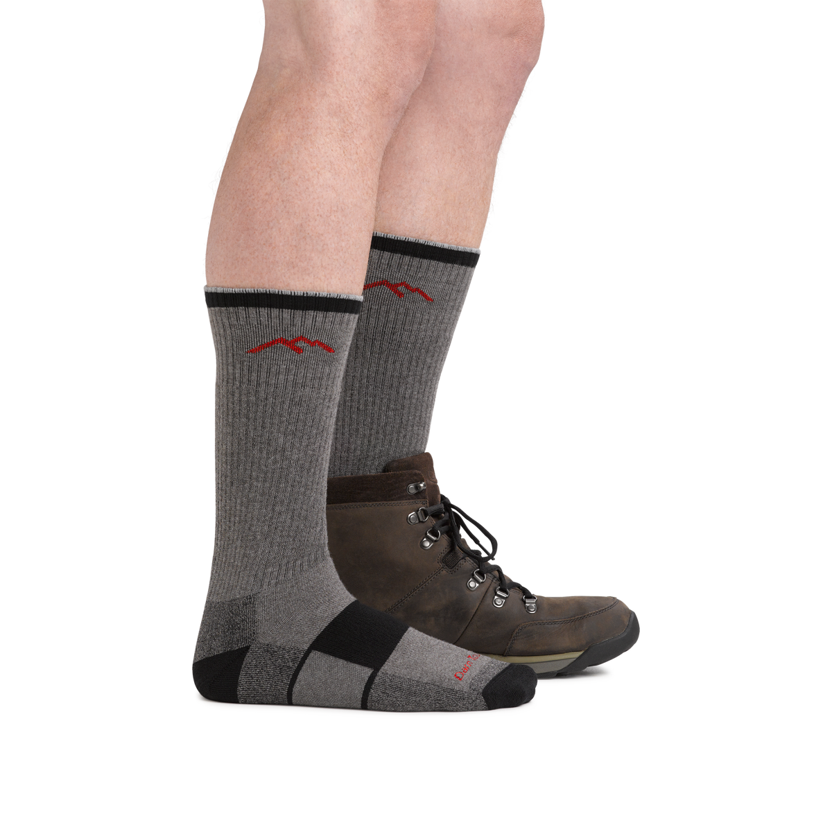 Model wearing gray and black Darn Tough hiking boot socks with brown leather hiking boots