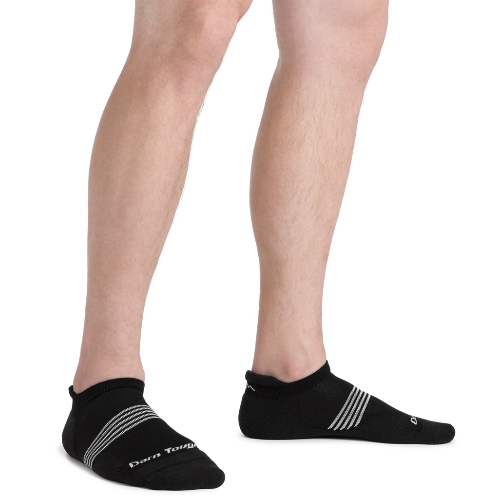 Model wearing Darn Tough black no-show tab socks with white stripe detail on ankle